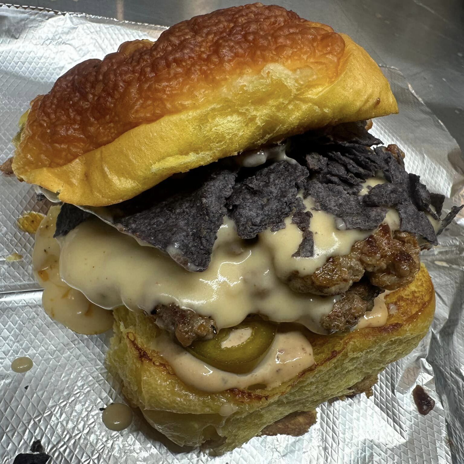 Margarita D Nacho Burger- Single or Double chorizoBeef smash patty, blueberry salsa, pepper jack cheese sauce, chipotle mayo, pickled jalapeno, blue corn chips on a toasted cheddar jalapeno bun Hodgepodge Bake Shop